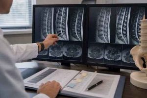 Physician comparing earlier and current spinal imaging beside a chronological record set